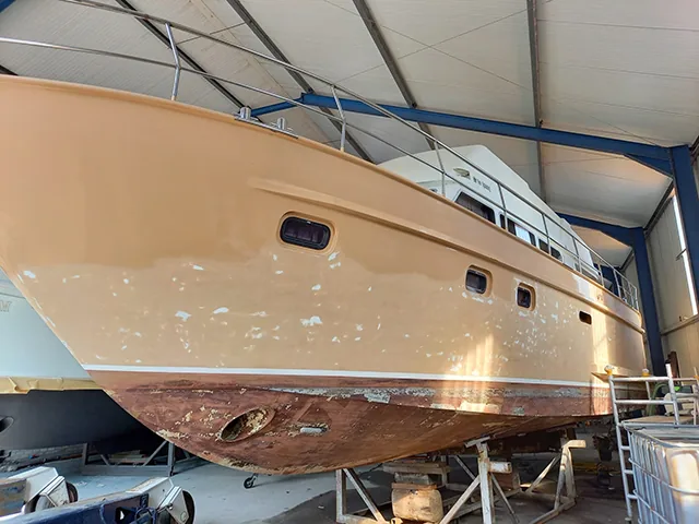 Jachtromp op stellingen in een loods, onderwaterschip geschilderd