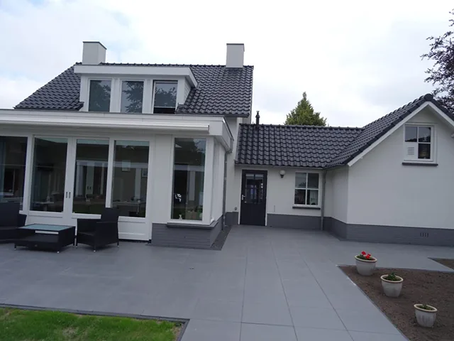 Witte vrijstaande woning met veranda en grijze tegels