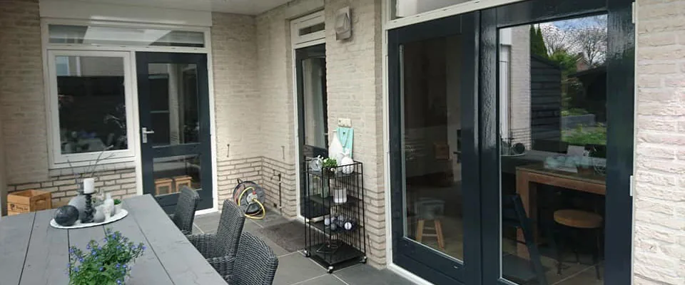 Veranda met donkere kozijnen en glazen schuifpui